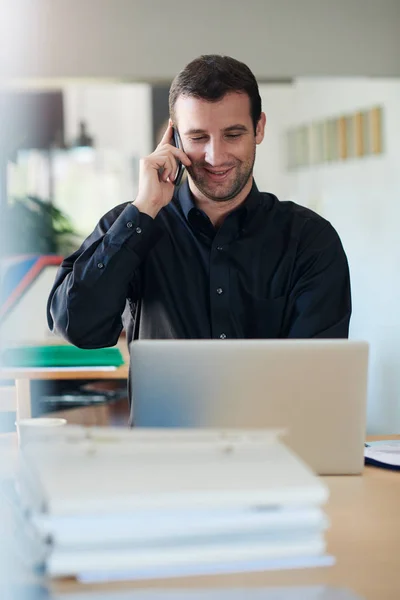 Uomo d'affari che parla al telefono e lavora al computer portatile — Foto Stock