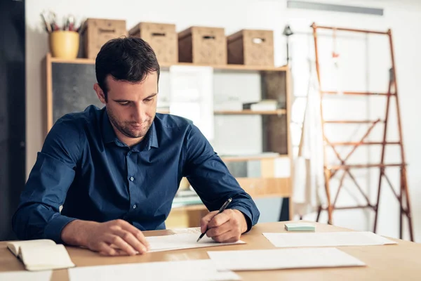 Jovem empresário passando por papelada — Fotografia de Stock