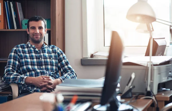 Young businessman sitting in office — Stock Photo, Image