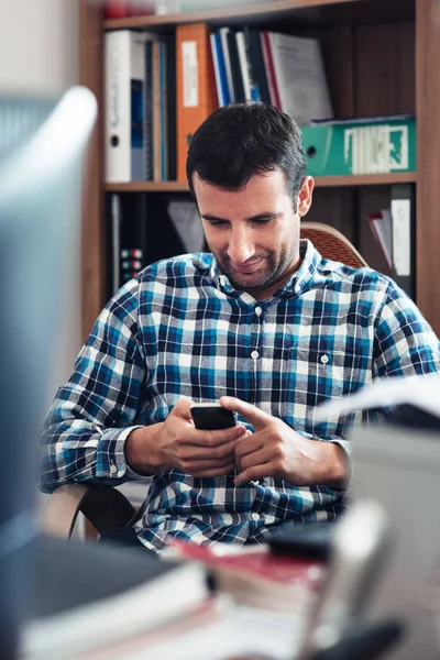 Homme d'affaires utilisant un téléphone portable dans le bureau — Photo