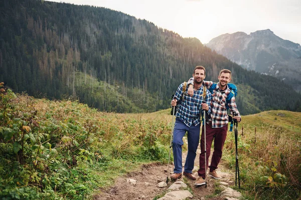 Улыбающиеся друзья путешествуют вместе по холмам — стоковое фото