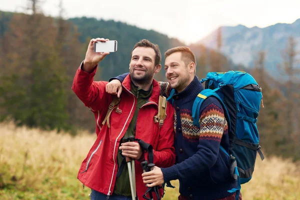 Homens tomando selfie enquanto trekking no deserto — Fotografia de Stock