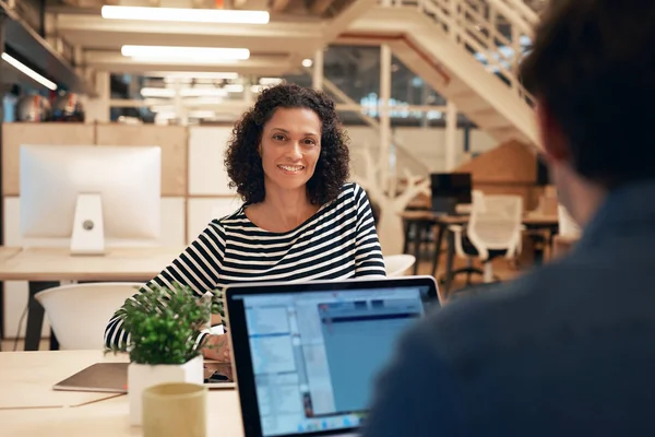 Mujer de negocios sonriente sentada en el escritorio — Foto de Stock