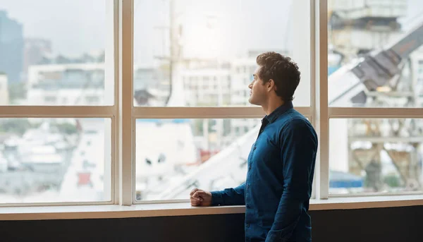 Empresário olhando através de janelas de escritório — Fotografia de Stock