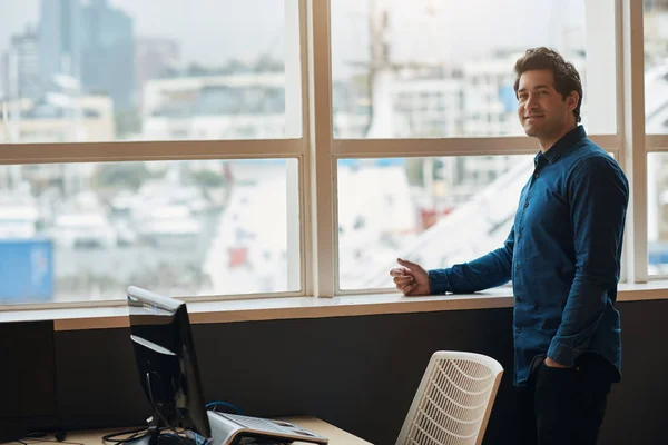 Empresário em pé junto às janelas do escritório — Fotografia de Stock