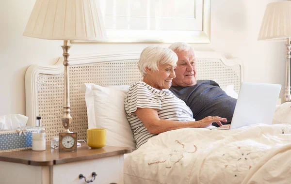 Coppia utilizzando laptop sul letto — Foto Stock