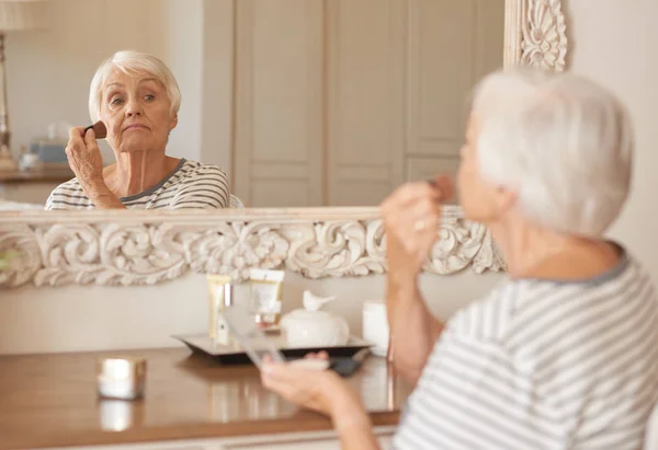 Senior woman applying foundation — Stock Photo, Image