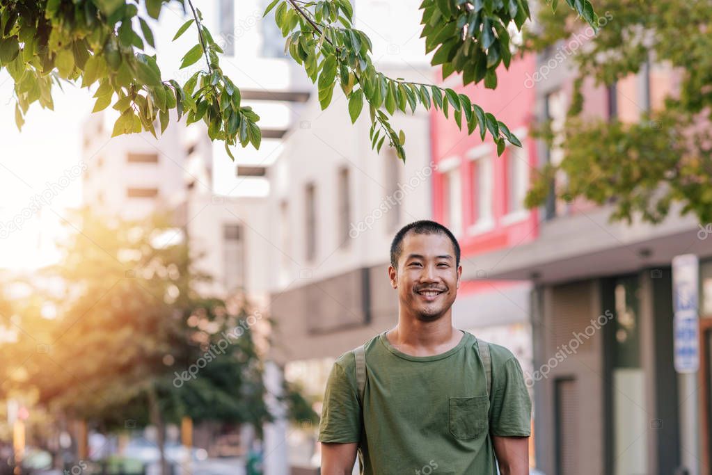 man smiling while standing alone 