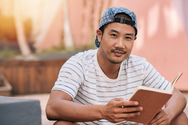Asian man reading novel