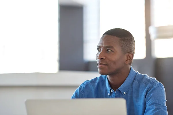 Empresário africano sentado em sua mesa — Fotografia de Stock