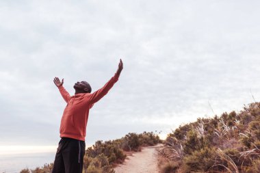 adam tepenin üzerinde kaldırdı kollarını 