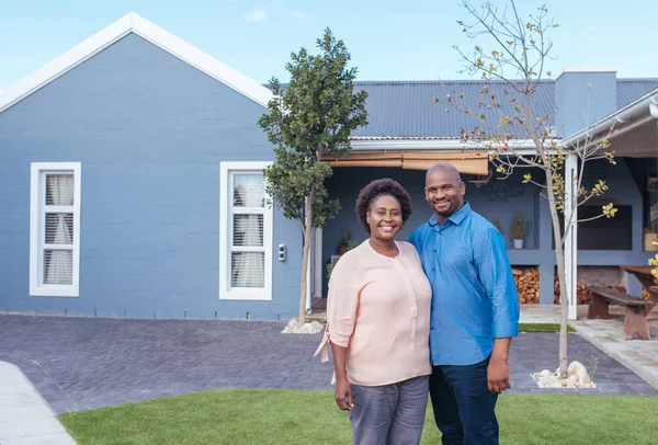 Couple standing in front of modern house — Stock Photo, Image