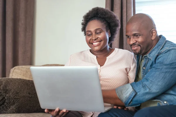 Coppia utilizzando laptop sul divano — Foto Stock