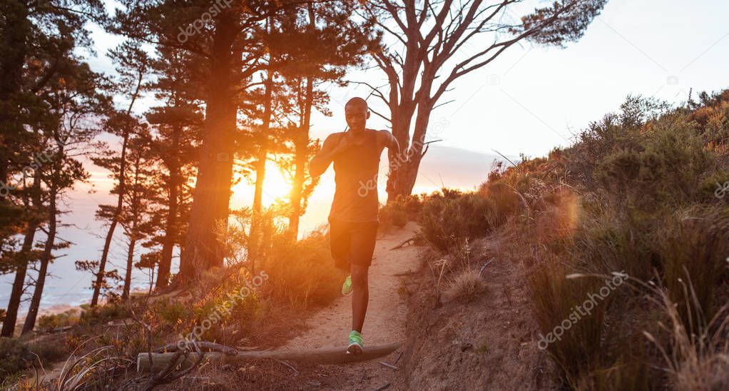 man running down trail in forest 