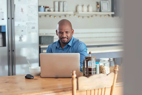 man at table using laptop