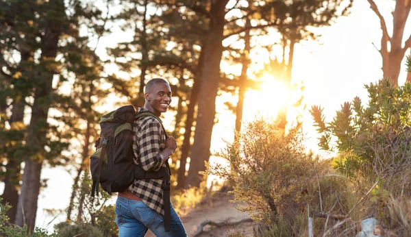 Homem usando mochila caminhando até trilha — Fotografia de Stock