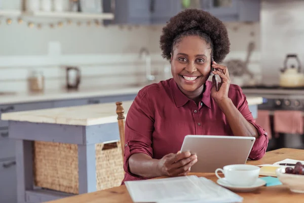 Woman using tablet and talking on cellphone — Stock Photo, Image