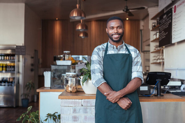 entrepreneur standing in front of counter of cafe 