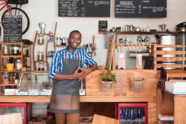 Unternehmer lehnt an Theke eines Cafés — Stockfoto