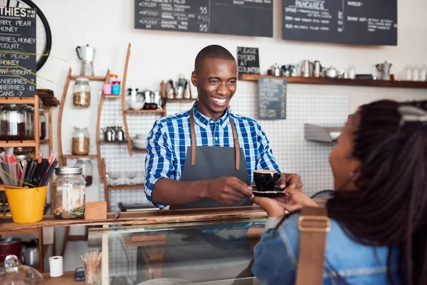 Jovem barista entregando café ao cliente — Fotografia de Stock