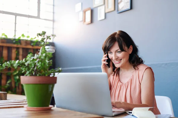 Femme d'affaires parlant sur téléphone portable et utilisant un ordinateur portable — Photo