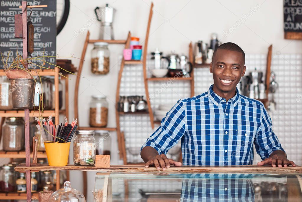 entrepreneur standing behind counter of cafe 