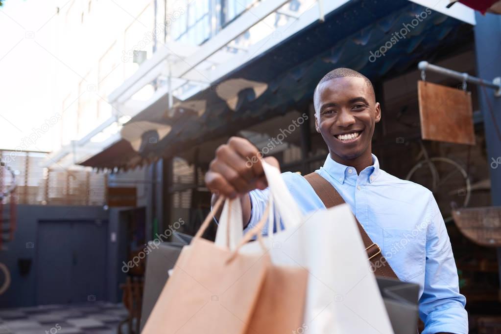 young man holding up shopping bags