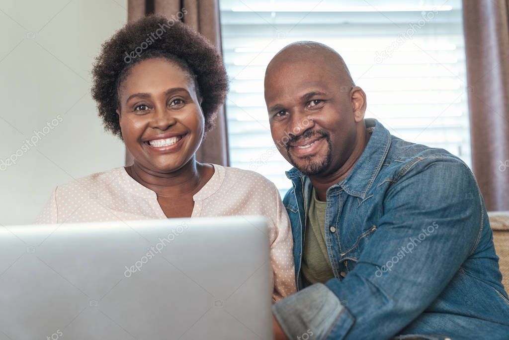 couple sitting at home and using laptop