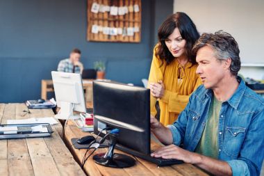 meslektaşları modern ofiste bilgisayar kullanarak