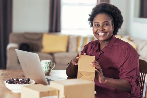 Vrouw schrijven adressen op pakketten — Stockfoto