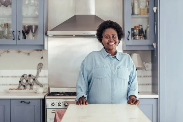 Mujer de pie en el mostrador en la cocina —  Fotos de Stock