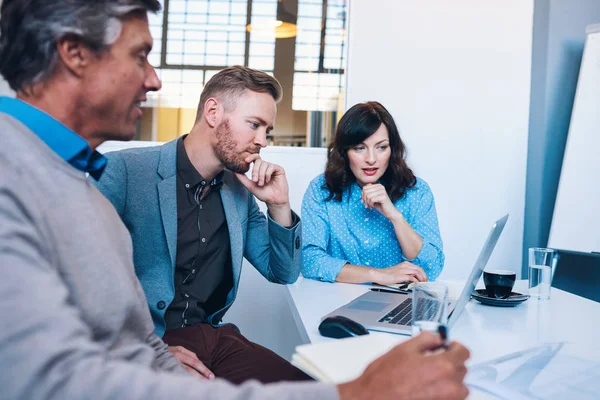 Collega's spreken en met behulp van laptop — Stockfoto