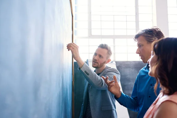 Colegas brainstorming juntos em um quadro-negro — Fotografia de Stock