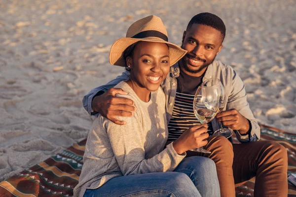 Pareja africana sentada en la playa —  Fotos de Stock