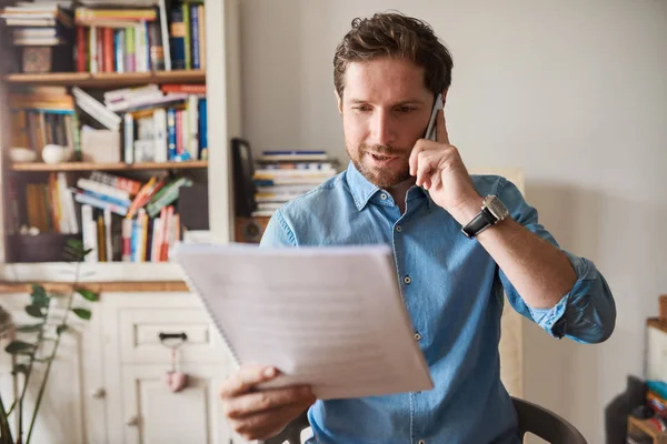 Jonge Man Zitten Aan Tafel Zijn Woonkamer Lezing Papierwerk Praten — Stockfoto