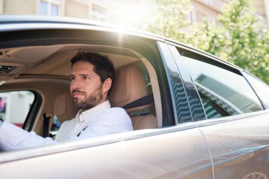 Gidip arabasını ve şehrin içinden onun sabah sırasında Sürüş sırasında gülümseyen direksiyonuna oturan genç adam