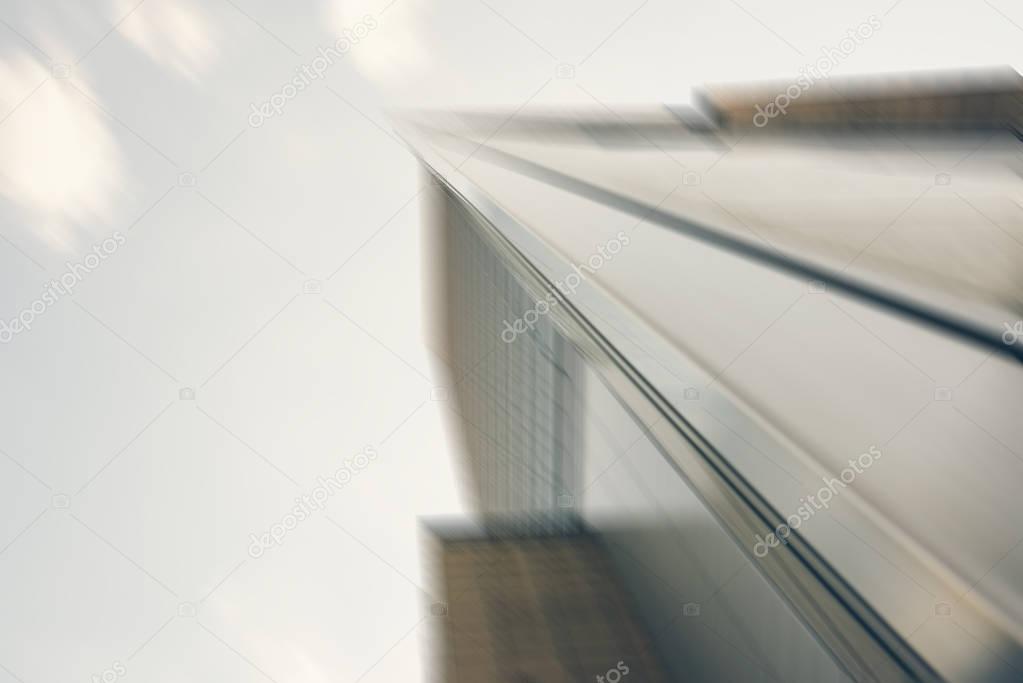 Abstract image of the modern glass exterior of skyscraper rising up to the sky in the commercial district of city