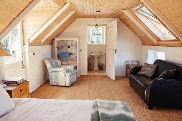 Interior of a comfortable master bedroom in the loft of a contemporary residential home with an en suite bathroom