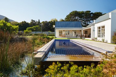 Dış çevre düzenlemesi arka bahçe ve Yüzme Havuzu ve çağdaş bir ülke güneşli bir ev