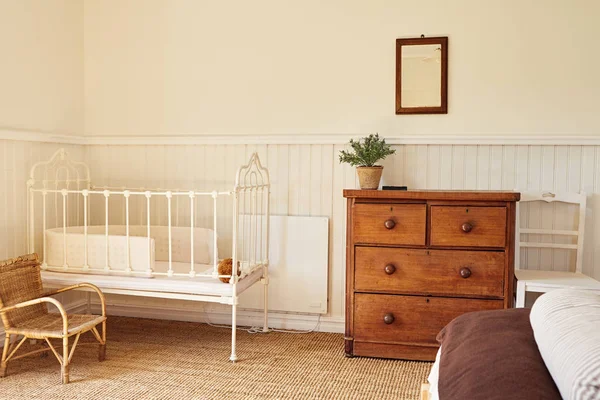 Interior of a bright master bedroom with a bed and baby's cot in a contemporary residential home