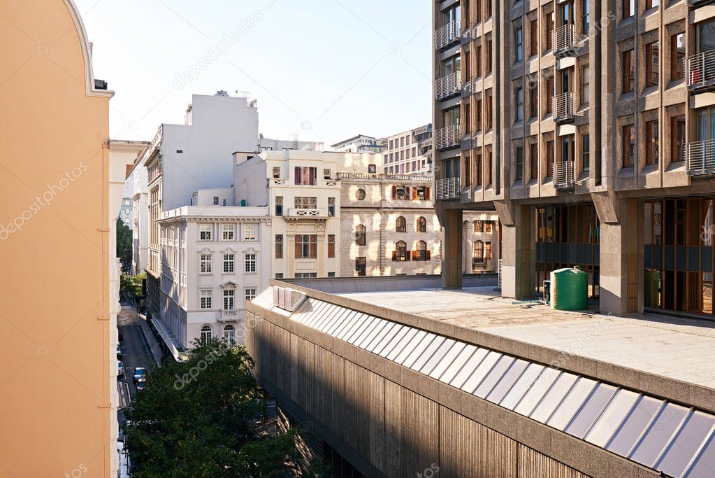 Modern and historical buildings on a street in the commercial district of a city on a sunny day