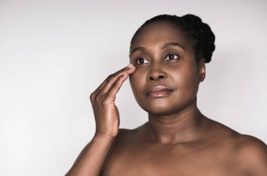 Mükemmel cilt cilt gözü beyaz bir arka plan karşı dururken yakınındaki incelenmesi ile Afrikalı kadın genç artı boyutu 