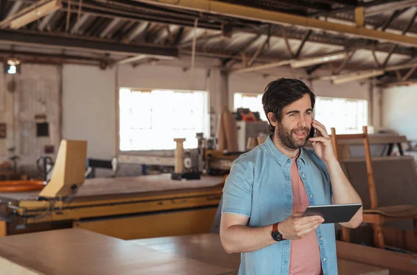 Young Woodworker Beard Talking Cellphone Using Digital Tablet While Standing — Stock Photo, Image