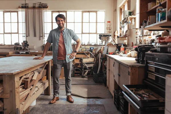 Portret Młodego Woodworker Uśmiechający Się Pewnie Stojąc Obok Workbench Pełna — Zdjęcie stockowe