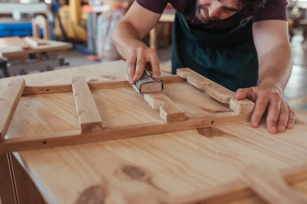Closeup of skilled carpenter hand sanding pieces of wooden furniture design while working in his large woodworking shop — Stock Image Closeup Skilled Carpenter Hand Sanding Pieces Wooden Furniture Design While Stock Image