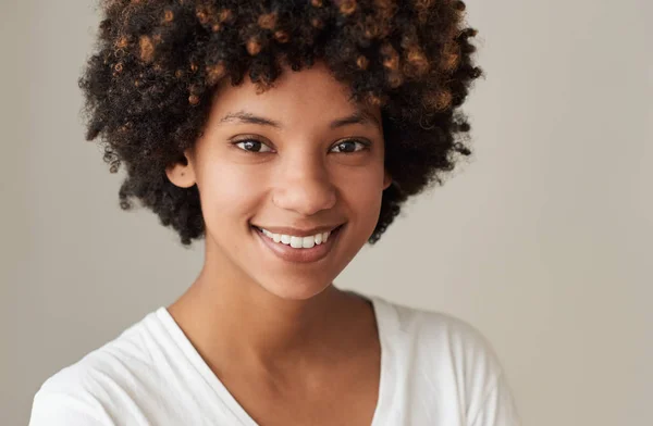 特写肖像的一个微笑的年轻非洲妇女与黑人和自然肤色站在灰色背景 — 图库照片
