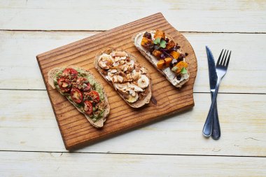 Bir ürün yelpazesine lezzetli açık yüzlü sandviç maddeler çeşitli yüksek açı ahşap tahta ve masa