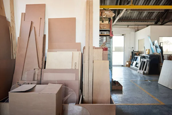 Boards stacked against a woodworking shop wall — ストック写真