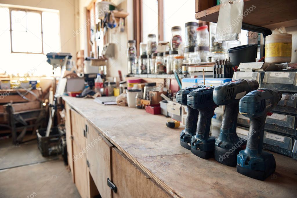 Drills sitting on a bench in a woodworking shop