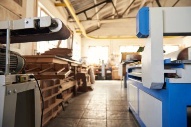 Large industrial sanding tool and other machinery inside of a large woodworking and carpentry workshop